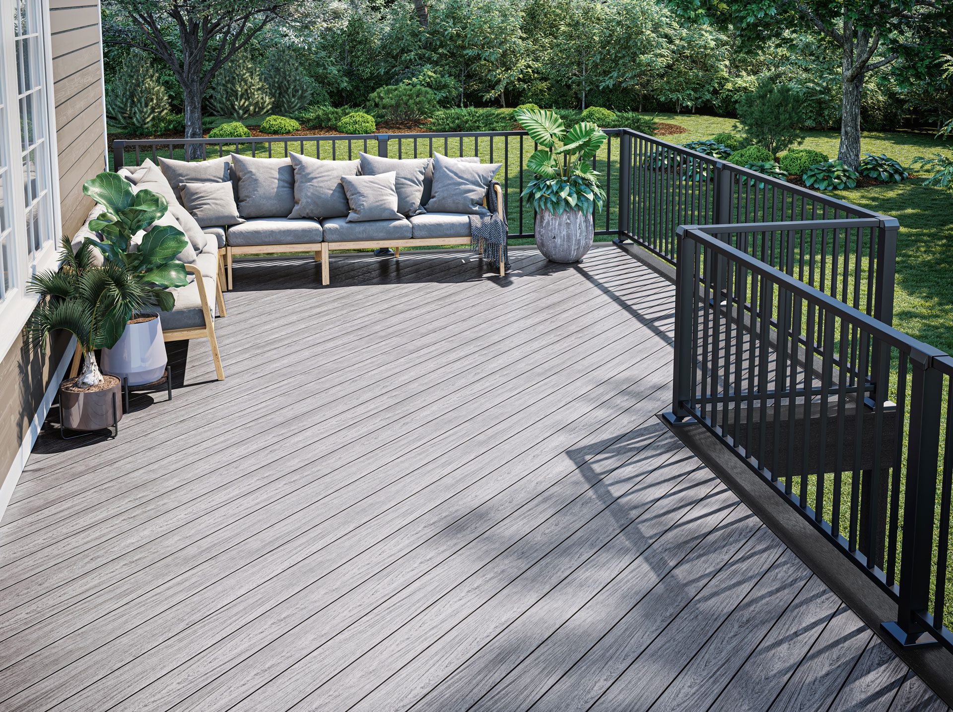 A residential deck with outdoor sectional and several potted plants.